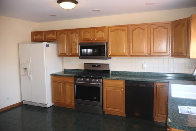 kitchen featuring stainless steel appliances, tasteful backsplash, brown cabinetry, and dark countertops