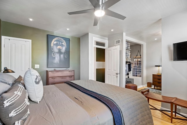 bedroom with a ceiling fan, wood finished floors, visible vents, and recessed lighting