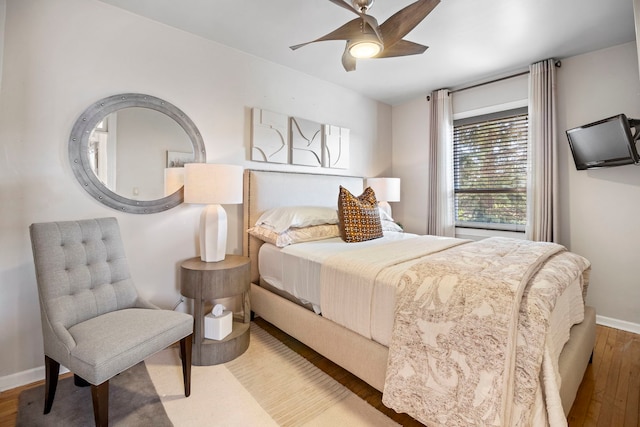 bedroom with a ceiling fan, baseboards, and wood finished floors