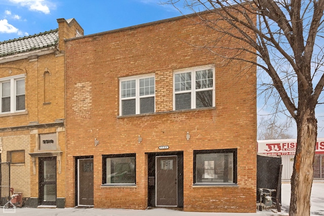 view of front of property featuring brick siding and a chimney