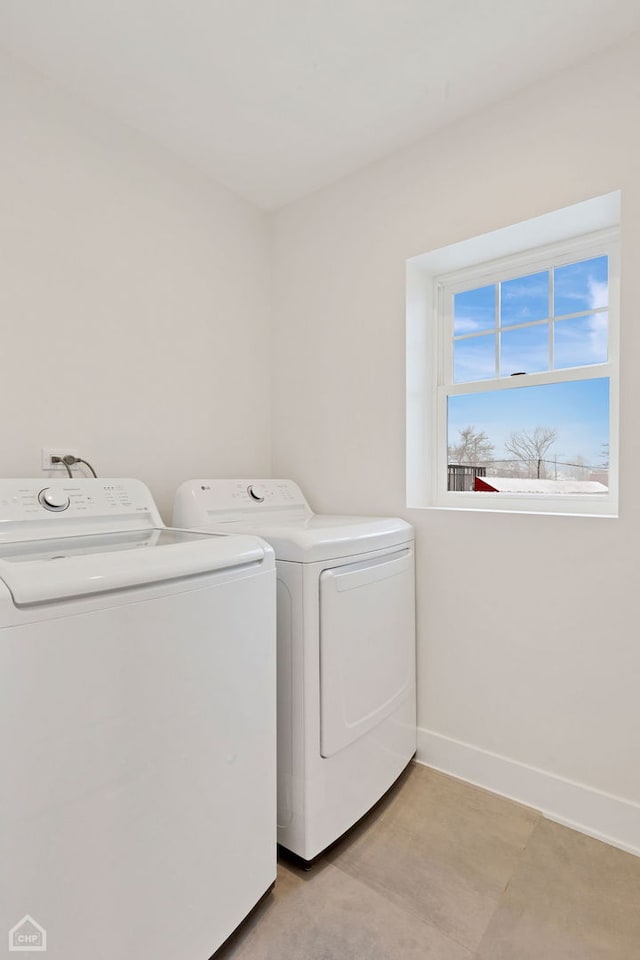 washroom with baseboards, laundry area, and washer and dryer