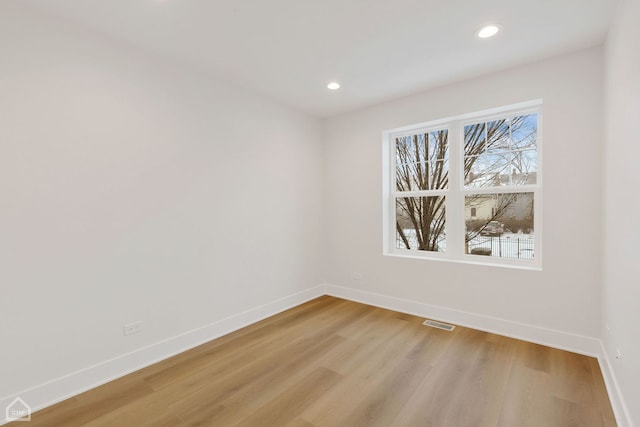 spare room featuring light wood finished floors, recessed lighting, visible vents, and baseboards