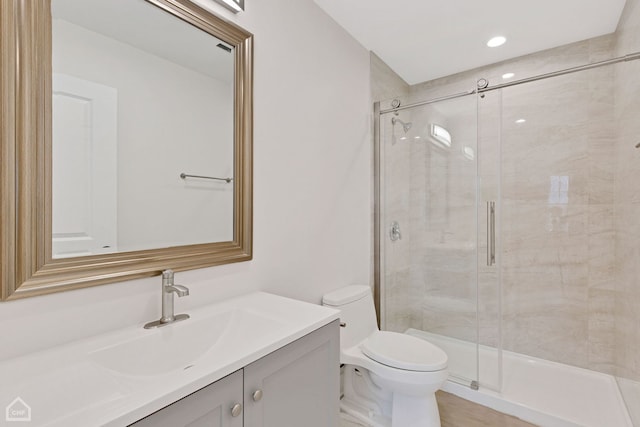 full bath featuring toilet, a shower stall, and vanity