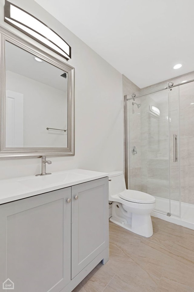 full bathroom with a stall shower, vanity, and toilet