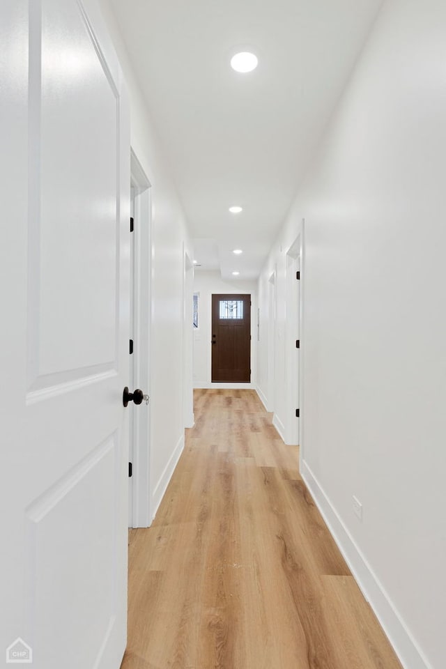 hallway with baseboards, recessed lighting, and light wood-style floors