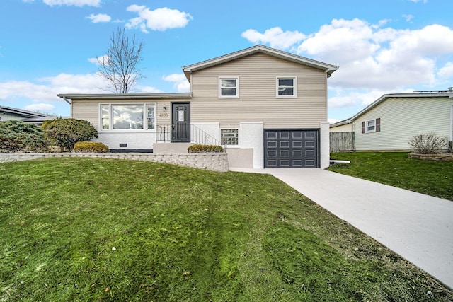 split level home with concrete driveway, a front lawn, an attached garage, and fence