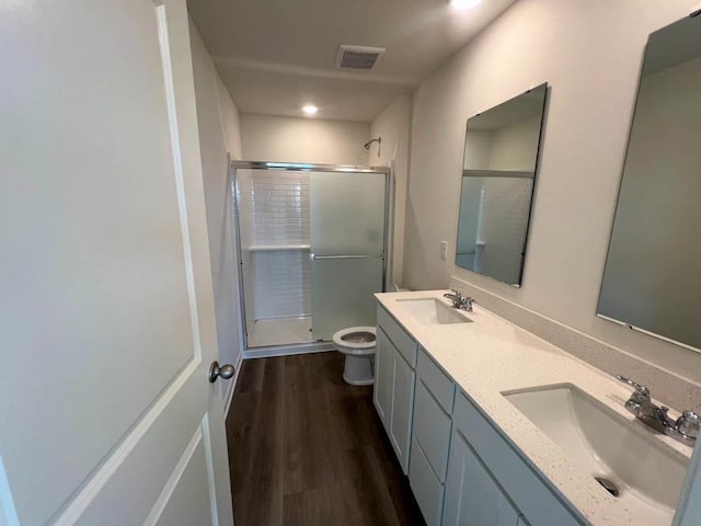 full bathroom with a stall shower, visible vents, a sink, and wood finished floors