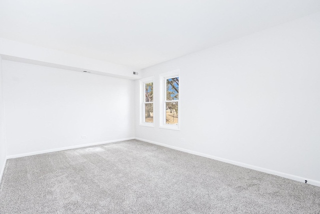 carpeted empty room featuring visible vents and baseboards