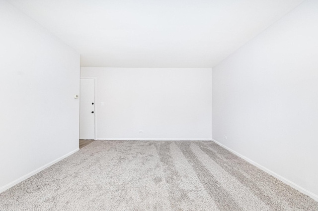 carpeted spare room with baseboards