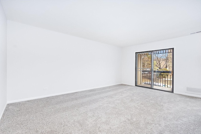 carpeted spare room with baseboards and visible vents