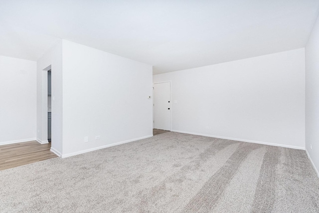 carpeted empty room with baseboards