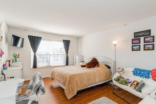 bedroom with wood finished floors and baseboards