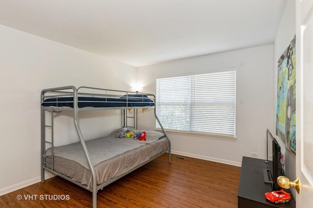 bedroom featuring wood finished floors, visible vents, and baseboards