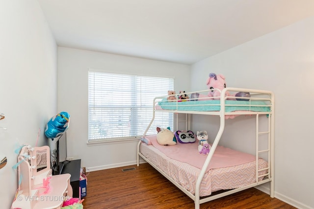 bedroom with visible vents, baseboards, and wood finished floors