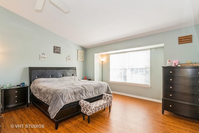 bedroom with a ceiling fan, lofted ceiling, baseboards, and wood finished floors