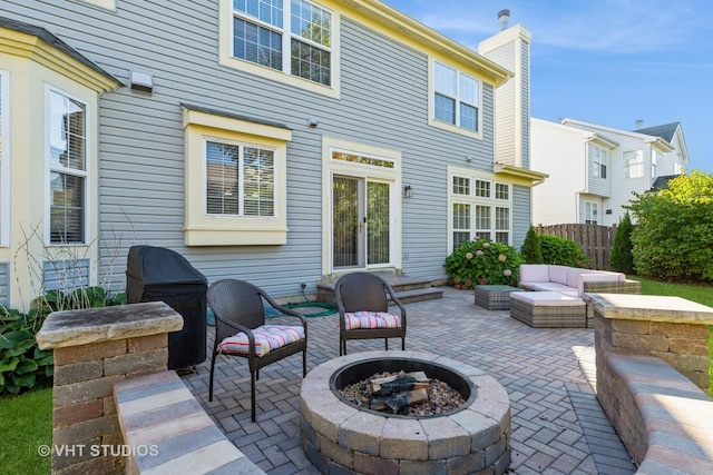 view of patio / terrace featuring an outdoor living space with a fire pit, fence, and french doors