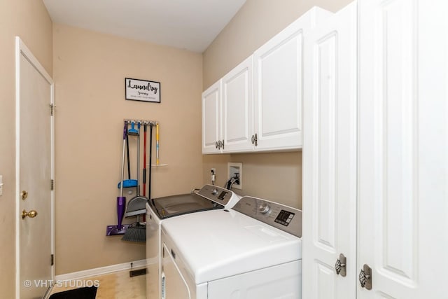 laundry room with washing machine and clothes dryer, cabinet space, and baseboards