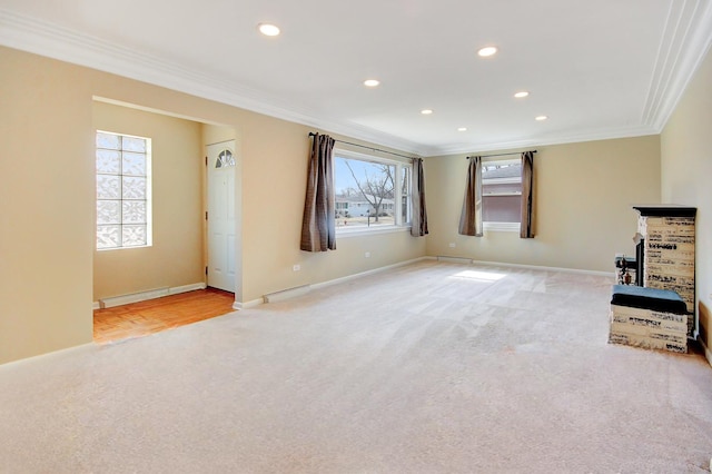 unfurnished living room featuring recessed lighting, a baseboard heating unit, light carpet, baseboards, and ornamental molding