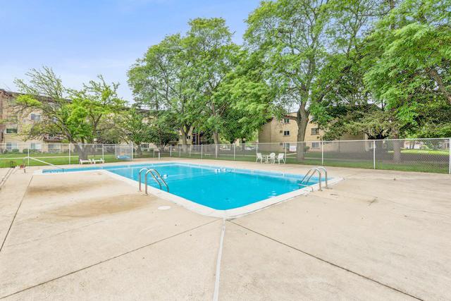 pool with a patio and fence