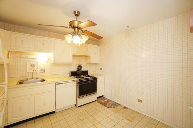 kitchen featuring gas range oven, white dishwasher, light countertops, white cabinetry, and a sink