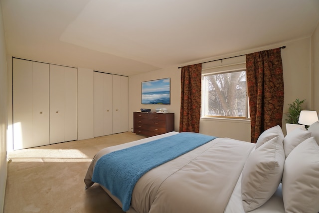 bedroom with carpet and two closets