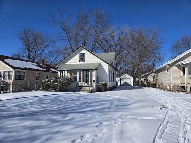 view of front of house featuring a porch, a detached garage, and an outdoor structure