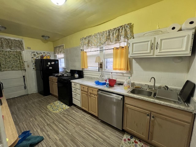 kitchen featuring a sink, light countertops, backsplash, black appliances, and light wood finished floors