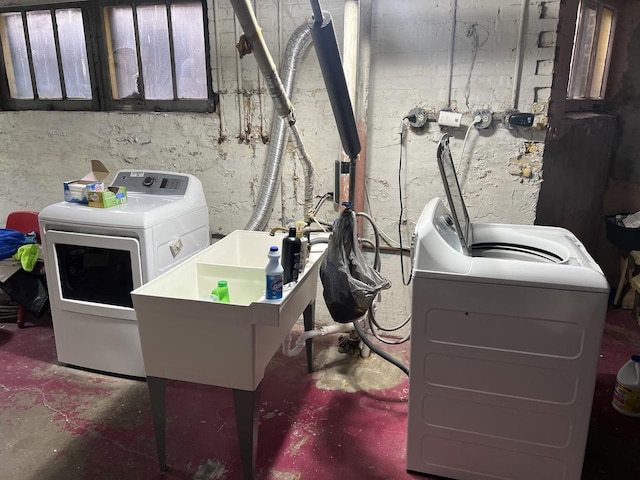 laundry area featuring laundry area, separate washer and dryer, and a sink