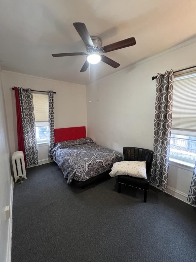 carpeted bedroom with ornamental molding, multiple windows, a ceiling fan, and baseboards