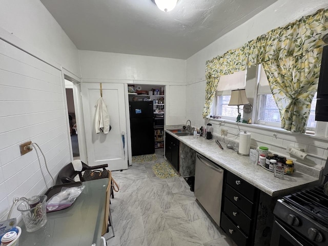 kitchen featuring a sink, black appliances, light countertops, and dark cabinets