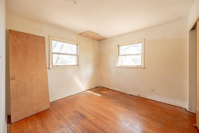 unfurnished room with hardwood / wood-style flooring and plenty of natural light