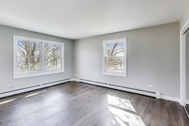 spare room featuring a baseboard radiator, baseboards, and wood finished floors