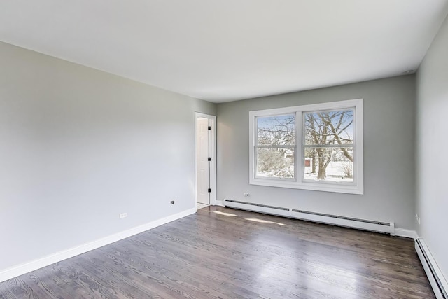 empty room featuring a baseboard radiator, baseboards, and dark wood finished floors