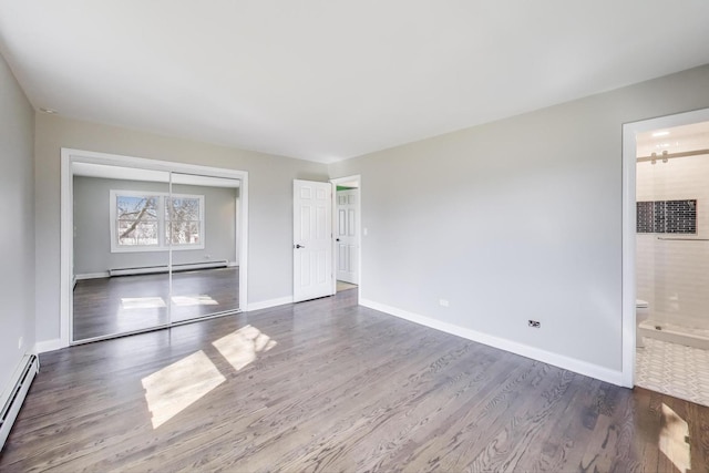 spare room with a baseboard radiator, baseboards, baseboard heating, and wood finished floors