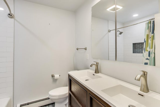 full bath with double vanity, toilet, a baseboard heating unit, and a sink