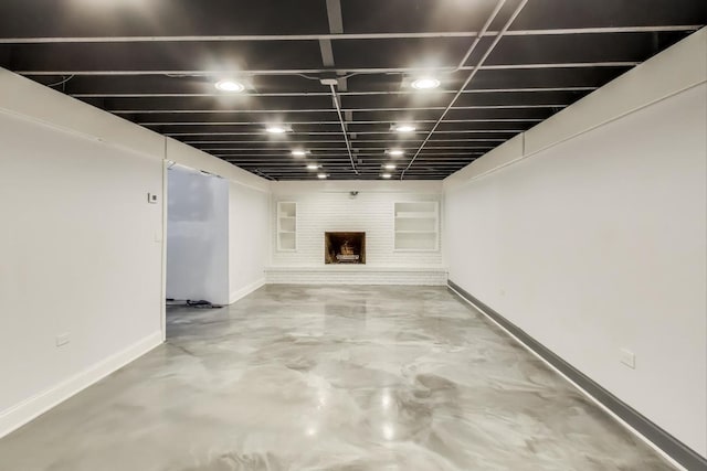 finished basement featuring baseboards and a large fireplace