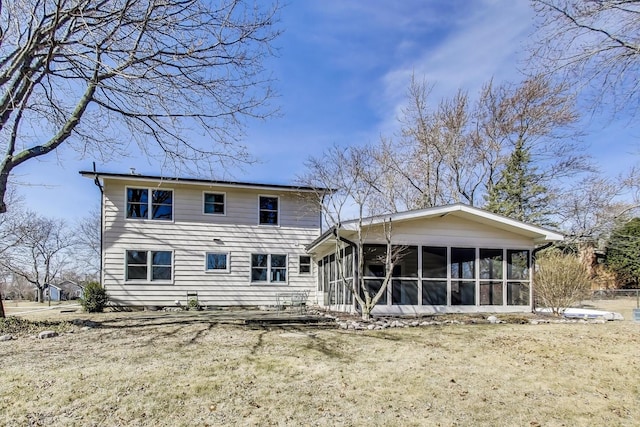 back of house with a yard and a sunroom