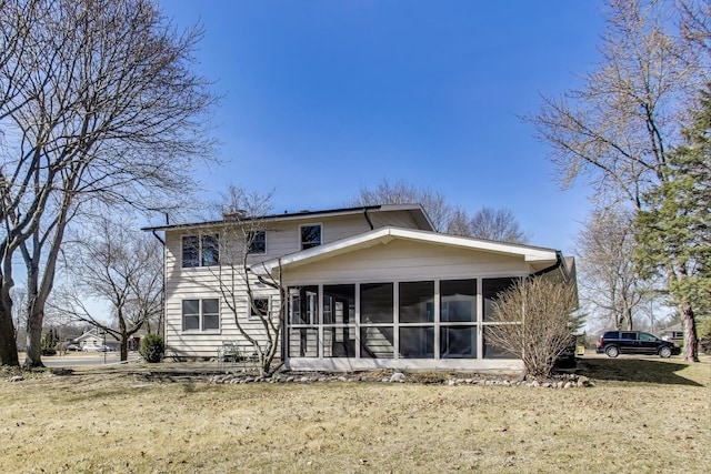 back of property with a yard and a sunroom