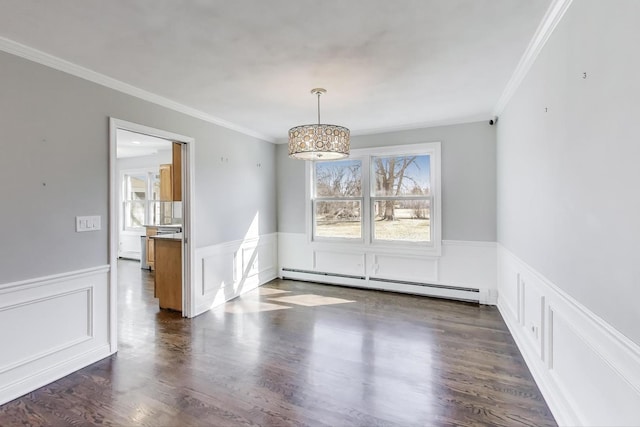 unfurnished dining area with dark wood finished floors, baseboard heating, and wainscoting