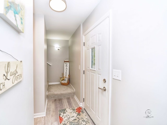 hall with light wood finished floors and baseboards