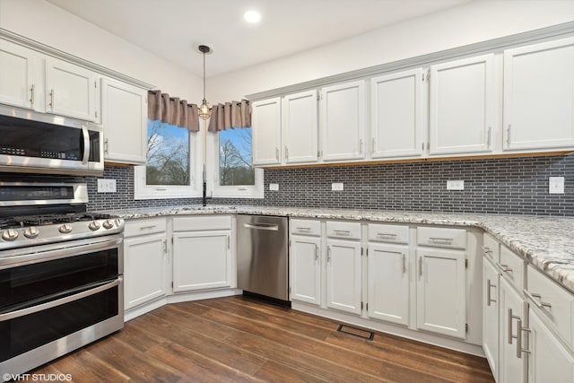 kitchen with white cabinetry, appliances with stainless steel finishes, decorative backsplash, and a sink