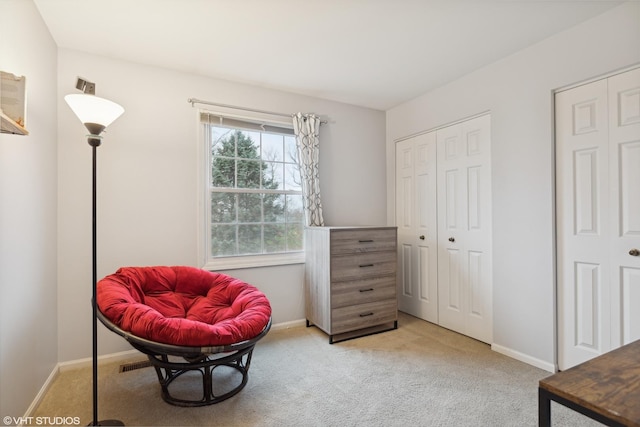 sitting room featuring baseboards and light colored carpet