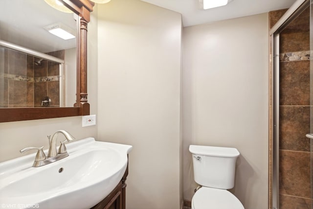 full bathroom with toilet, a sink, and a stall shower