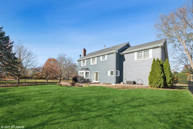 back of house with fence, a chimney, a yard, and central AC unit