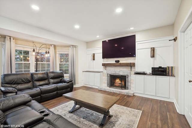 living area featuring recessed lighting, baseboards, a lit fireplace, and dark wood-style flooring