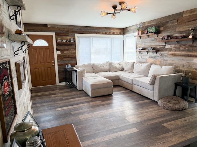 living area featuring wood walls, wood finished floors, and a notable chandelier