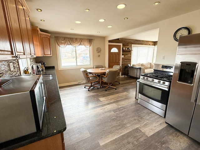 kitchen with stainless steel appliances, dark countertops, and a healthy amount of sunlight