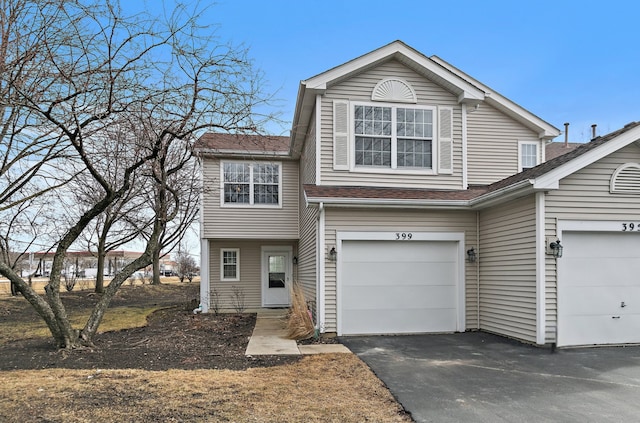 view of front of home featuring roof with shingles, driveway, and an attached garage