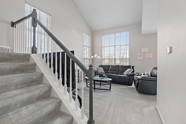 stairway featuring carpet floors, high vaulted ceiling, and baseboards