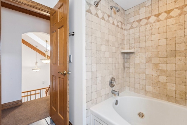 bathroom with shower / bathing tub combination and baseboards